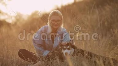 女人和狗在大自然中玩耍。 与宠物一起享受夏日时光。